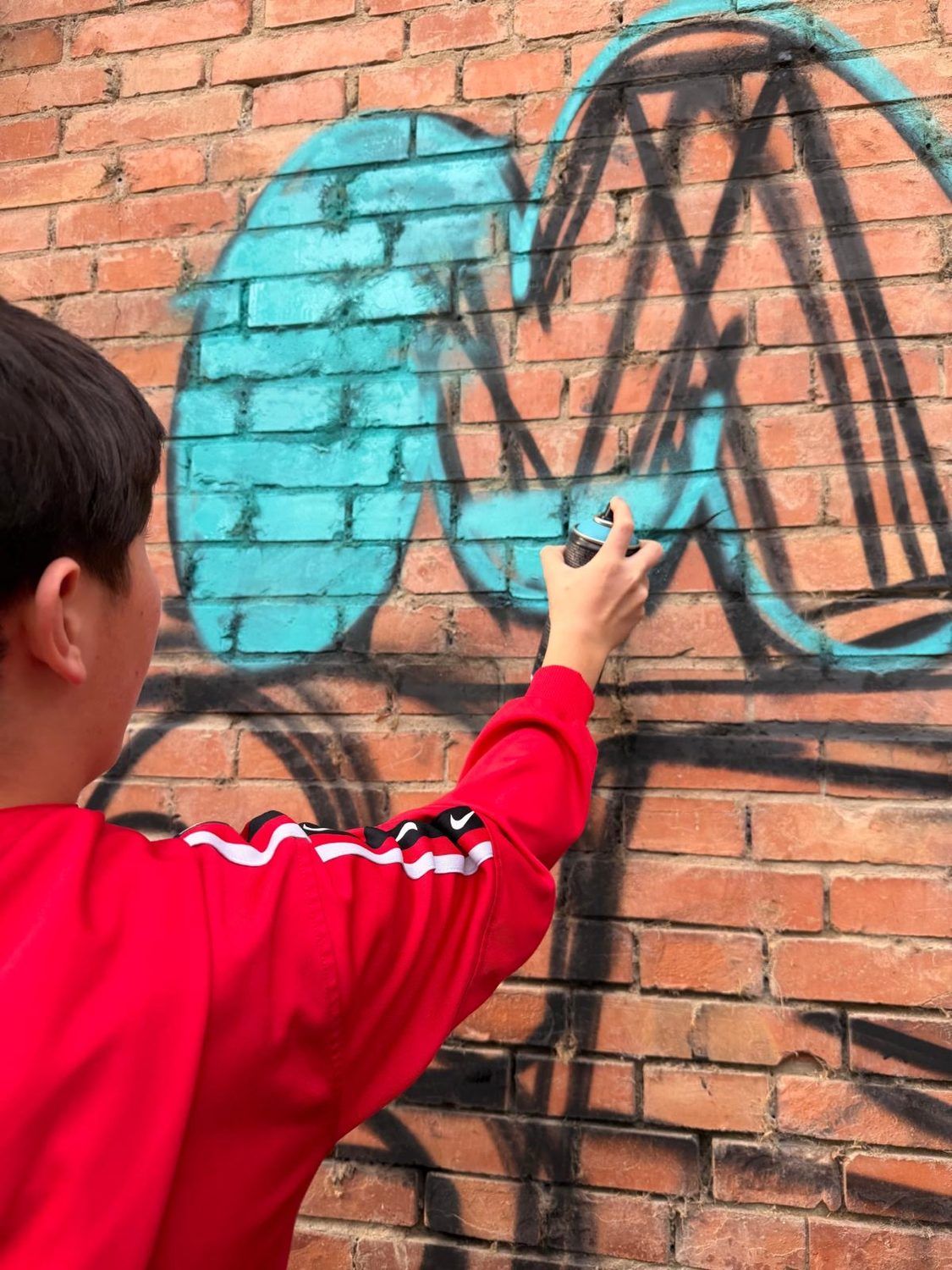 Filling in the letters with spray paint during the workshop